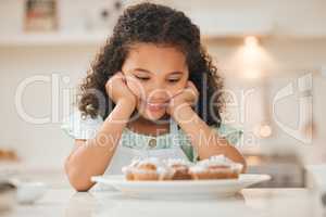 I dont know if I could wait any longer. a little girl patiently waiting to eat the freshly baked cupcakes.