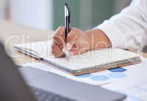 Businessperson writing in a notebook working in an office at work. Closeup of a business professional holding a pen and taking notes in a diary. Person writing ideas in a book