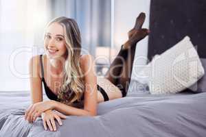 Why save it for a special occasion when everyday is special. an attractive young woman wearing lingerie and relaxing on the bed at home.