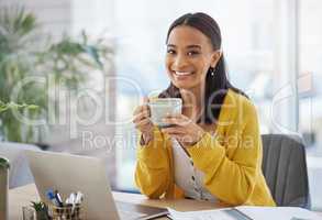 Coffee before work. a young businesswoman drinking coffee in a modern office at work.