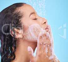 Speciality face products are always a winner. Studio shot of an attractive young woman showering against a blue background.