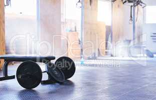 Add weight to lose weight. Still life shot of a barbell and weight plates in an empty gym.