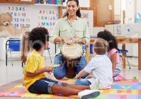 This is how you play it. Shot of a woman teaching her class about musical instruments.