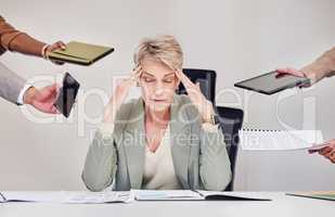 The joys of being their manager. a mature businesswoman sitting in the office and feeling stressed while her colleagues put pressure on her.