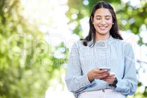 Striking a connection at every moment. a young businesswoman using a cellphone in the city.