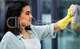 Cleaner windows for a better view. Closeup shot of a woman wearing gloves and using a cloth while cleaning windows.
