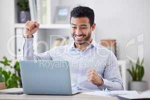 Young happy and excited mixed race businessman cheering with his fist working on a laptop sitting in an office at work. Hispanic businessperson celebrating a win. Man smiling after an achievement
