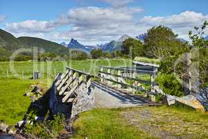 Landscape of wooden bridge in remote green countryside of Bodo in Nordland, Norway. Infrastructure and built crossing in eco meadow and environment fields. Toursim and exploring nature during the day