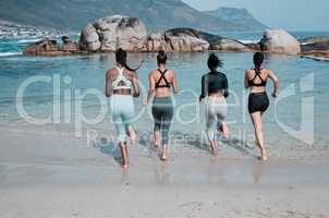 The water is freezing but refreshing. a group of friends frolicking on the beach together.