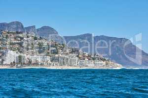 Scenic view of sea and blue sky at Camps Bay beach with the Twelve Apostles mountains in the background. Peaceful seascape ocean with copy space and building infrastructure in Cape Town, South Africa