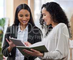 I cant wait to implement this. two businesswomen working together while using a digital tablet.