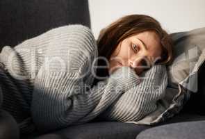 Havent felt this helpless in a while. Shot of a young woman lying on her couch feeling depressed.