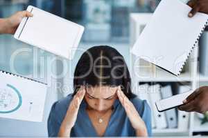 I cant cope with all of this at once. Shot of a young call centre agent looking stressed out while working in a demanding office environment.
