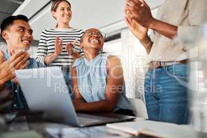 Group of diverse businesspeople having a meeting in an office at work. Happy business professionals clapping for their colleagues achievement together. Cheerful african american businesswoman being applauded by her coworkers