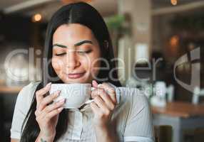 The perfect brew. a young woman enjoying a cup of coffee in a cafe.