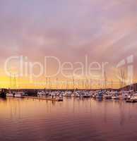 Scenic view of private yachts docked in water harbor at sunset in Bodo, Norway. Nautical transport vessels and boats in a dockyard in the morning at dawn before sailing on the ocean, sea or lake