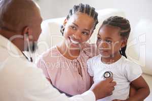 African american male paediatrician examining sick girl with stethoscope during visit with mom. Doctor checking heart lungs during checkup in hospital. Smiling daughter receiving medical care