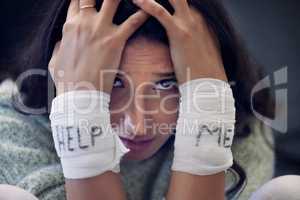 Im at my wits end. a young woman with bandages wrapped around her wrists showing help written on them.