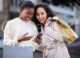 Youre the only one I want to spend time with. two friends using a smartphone during a day of shopping.