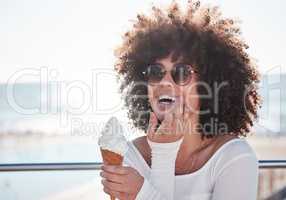 Summer is for indulging in all the desserts. a young woman enjoying an ice cream cone outdoors.