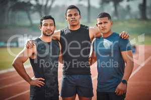 Were taking gold at the olympics. Cropped portrait of three handsome young male athletes standing together on an outdoor running track.