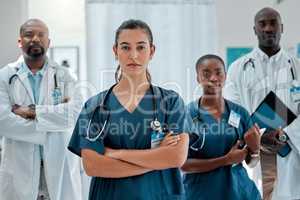 Group of serious diverse doctors standing with their arms crossed while working at a hospital. Focused expert medical professionals at work together at a clinic