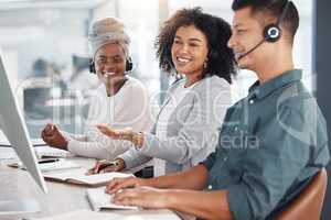 Young mixed race female call centre telemarketing agent discussing plans with colleagues while working together on a computer in an office. Consultants troubleshooting solution for customer service and sales support