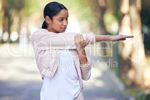 Shes up early to make headway towards her goals. a sporty young woman stretching her arms while exercising outdoors.