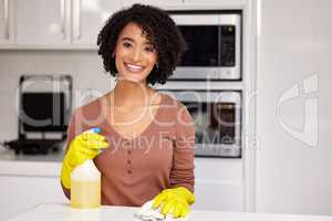 Lets get this house clean and sparkly. a young woman cleaning the kitchen counter at home.