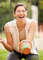 When creativity blossoms, thinking emanates. s young woman painting a pot in the garden at home.