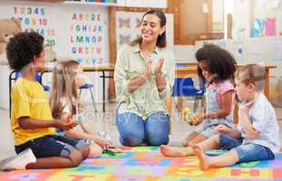 If you happy and you know it, clap your hands. Shot of a teacher singing with her preschool children.