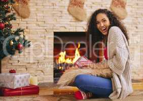 A little something to knock your Christmas socks off. a happy young woman opening presents during Christmas at home.