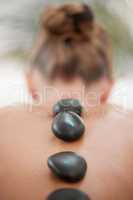 The more the merrier. a woman resting with hot stones on her back during a trip to the spa.