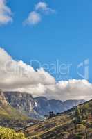 Landscape of the 12 apostles mountain range in Cape Town, South Africa looking beautiful with blue sky, white and grey clouds. Stunning view of mountains and nearby trees on a hill with copy space