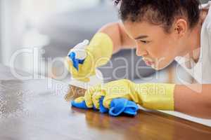 Shes ready to tackle any stain. a young woman cleaning her coffee table.