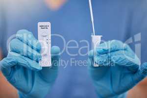 Unrecognizable doctor holding a covid test and a cotton swab while working alone at a hospital. One unrecognizable nurse working with a cotton swab and covid test at a clinic