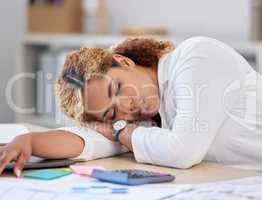 Young mixed race businesswoman sleeping while working in an office at work. One stressed hispanic businessperson taking a nap at work. Business professional resting in her office