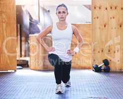 Shaping up to better form. Portrait of a sporty young woman doing lunges while exercising in a gym.