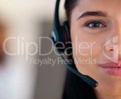 Closeup portrait of one young caucasian call centre telemarketing agent talking on headset while working in office. Face divided in half of friendly businesswoman operating helpdesk for customer service and sales support