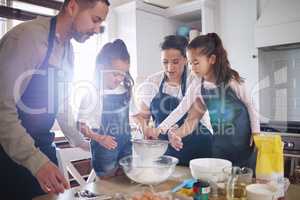 We bake for every occasion. Shot of a couple and their children baking together at home.
