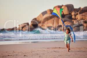 Fly high for you are destined for greatness. a little girl playing with her kite on the beach.