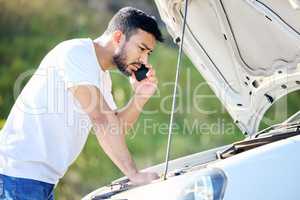 Before anything else, preparation is the key to success. Shot of a handsome young man on the phone with roadside assistance after suffering a vehicle breakdown.