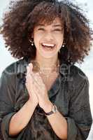 Portrait of a young beautiful mixed race woman with natural curly afro hair style smiling and laughing outside. Young hispanic female expressing joy and confidence with her radiant smile.A beautiful woman is one with a beautiful heart