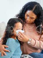 A mother will be there to take care of you. a young mother helping her daughter blow her nose at home.