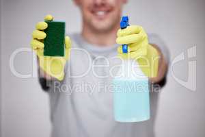 The best cleaning combo. an unrecognizable man holding a sponge and spray bottle against a grey background.