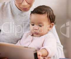 Happiness is your babys first toothless smile. a mother using a tablet with her baby at home.