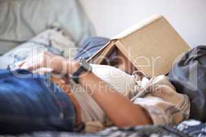 No hurricane will wake her. Shot of an unrecognizable student passed out while studying in her bedroom.