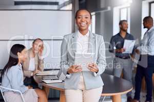 Technology is invited to all our board meetings. Cropped portrait of an attractive young businesswoman standing with a tablet in the boardroom and her colleagues in the background.