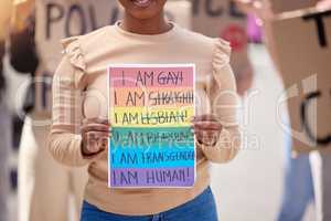 Love is a human condition. a woman holding up a sign at an lgbtq rally.