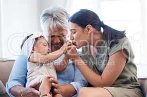 Happiness starts with happy wives. a mature woman bonding with her daughter and granddaughter on the sofa.